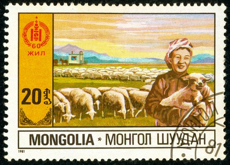 Ukraine - circa 2018: A postage stamp printed in Mongolia shows Sheep Farming. A woman is holding a lamb in her hands. Herd of sheep. Series: 60 Years of Independence. Circa 1981.のeditorial素材