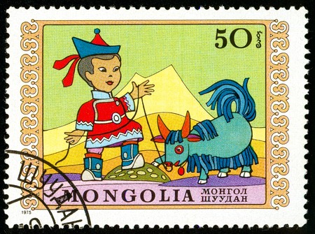 Ukraine - circa 2018: A postage stamp printed in Mongolia show Boy and obedient little yak. Series: International Childrens Day. Circa 1975.のeditorial素材