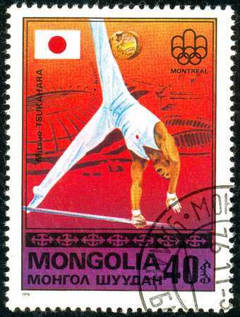 Ukraine - circa 2018: A postage stamp printed in Mongolia show gymnast Mitsuo Tsukahara and Japanese flag. Series: Medalists from Montreal. Circa 1976のeditorial素材