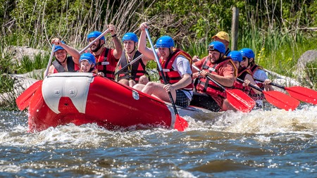 Myhiya, Ukraine - May 1, 2018: Place for recreation, ecological water tourism. Rafting, kayaking. Close-up view of oars with splashing water. A group of people with a child on a rubber inflatable boatのeditorial素材