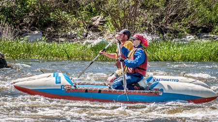 Myhiya, Ukraine - May 1, 2018: Rafting, kayaking. Young married couple sailing on a rubber inflatable boat in a stormy stream of water. Water splashes close-up. Ecological water tourism.のeditorial素材