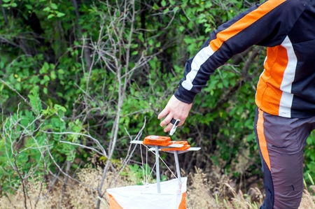 Orienteering. Check point Prism and composter for orienteering. The athlete marks the passage of the control point. Orienteering raceの写真素材