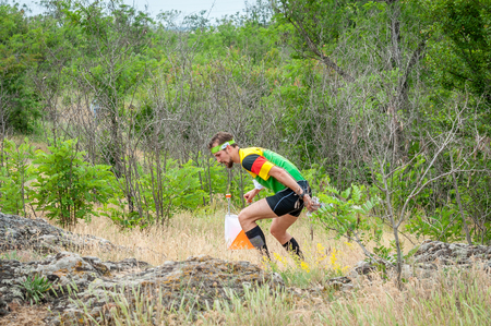 Yuzhnoukrainsk, Ukraine - May 26, 2018: Orienteering race. Traditional annual orienteering game Partisan Spark Cup 2018. The athlete marks the passage of the control pointのeditorial素材