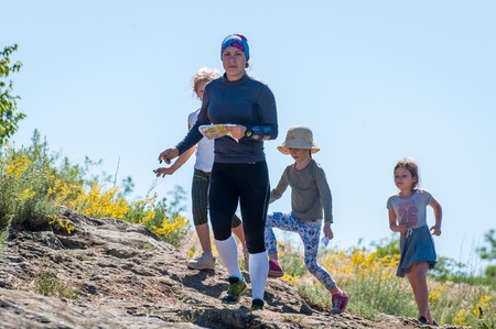 Yuzhnoukrainsk, Ukraine - May 26, 2018: Orienteering race. Traditional annual orienteering game Partisan Spark Cup 2018. An adult athlete and a group of children-athletes on the route of orienteeringのeditorial素材