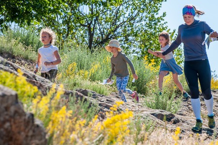 Yuzhnoukrainsk, Ukraine - May 26, 2018: Orienteering race. Traditional annual orienteering game Partisan Spark Cup 2018. An adult athlete and a group of children-athletes on the route of orienteeringのeditorial素材