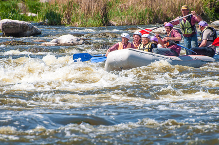 Myhiya, Ukraine - May 1, 2018: Rafting. Cheerful group of people aged are sailing on a rubber inflatable boat. Teamwork. Extreme sport. Ecological water tourism. Positive emotions, adrenalineのeditorial素材
