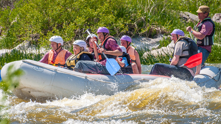 Myhiya, Ukraine - May 1, 2018: Rafting. Cheerful group of people aged are sailing on a rubber inflatable boat. Teamwork. Extreme sport. Ecological water tourism. Positive emotions, adrenalineのeditorial素材