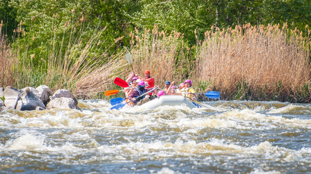 Myhiya, Ukraine - May 1, 2018: Rafting. Merry company of people of different ages sailing on a rubber inflatable boat. Teamwork. Extreme sport. Ecological water tourism. Positive emotions, adrenalineのeditorial素材