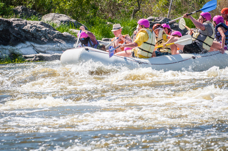 Myhiya, Ukraine - May 1, 2018: Rafting. Merry company of people of different ages sailing on a rubber inflatable boat. Teamwork. Extreme sport. Ecological water tourism. Positive emotions, adrenalineのeditorial素材