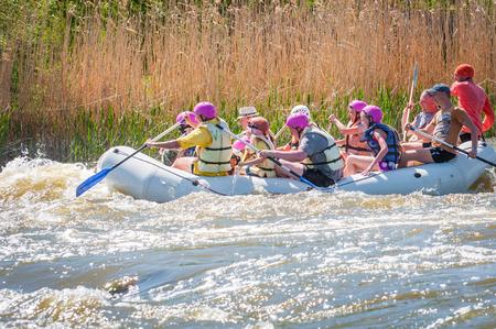 Myhiya, Ukraine - May 1, 2018: Rafting. Merry company of people of different ages sailing on a rubber inflatable boat. Teamwork. Extreme sport. Ecological water tourism. Positive emotions, adrenalineのeditorial素材