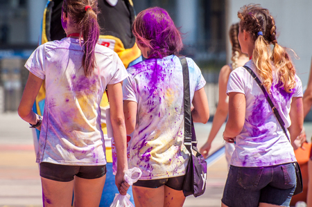 Holiday Holi. Three young girls are sprinkled with bright violet powdersの写真素材