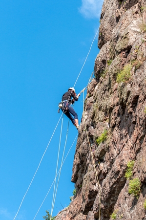 Rock climbing. A young climber climbs a vertical granite rock. Extreme sportの写真素材