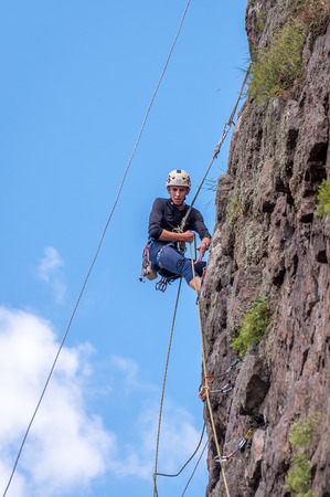 Yuzhnoukrainsk, Ukraine - June 19, 2018: Rock climbing. A young climber climbs a vertical granite rock. Extreme sport. Training of mountaineers.のeditorial素材
