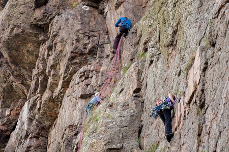 Yuzhnoukrainsk, Ukraine - June 20, 2018: Rock climbing. A group of young rock climbers climb the vertical granite rock. Extreme sport. Training of mountaineersのeditorial素材