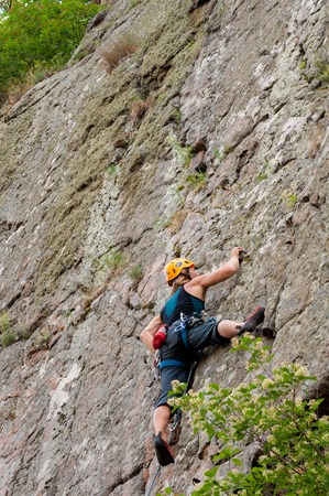 Yuzhnoukrainsk, Ukraine - June 20, 2018: Rock climbing. A group of young rock climbers climb the vertical granite rock. Extreme sport. Training of mountaineersのeditorial素材