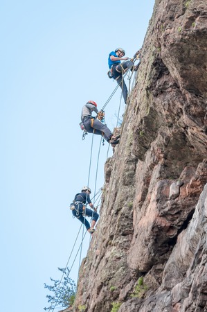 Yuzhnoukrainsk, Ukraine - June 20, 2018: Rock climbing. A group of young rock climbers climb the vertical granite rock. Extreme sport. Training of mountaineersのeditorial素材