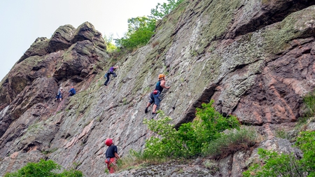 Yuzhnoukrainsk, Ukraine - June 20, 2018: Rock climbing. A group of young rock climbers climb the vertical granite rock. Extreme sport. Training of mountaineersのeditorial素材