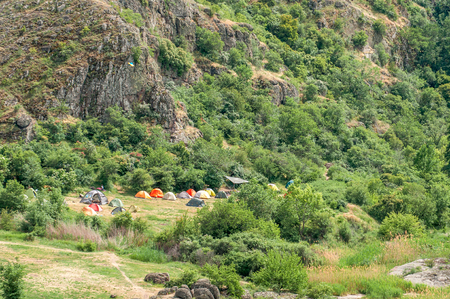 A tent city. Tourists arranged a bivouac at the foot of the rocks. A Ukrainian flag was raised in the campの写真素材