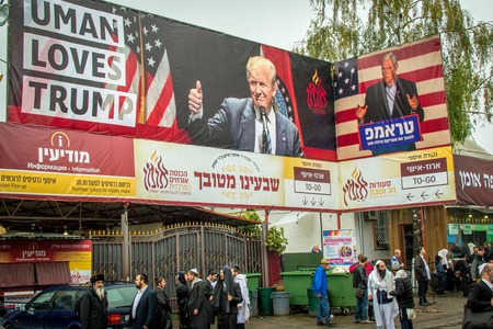Uman, Ukraine - 10 September 2018: Rosh Hashanah. Pilgrims of the Hasidim on the street of the city of Uman. A large poster with the inscription Uman loves Trump. Everywhere garbage.のeditorial素材