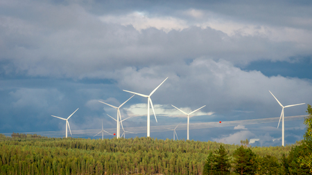 Wind turbines, converting the wind's kinetic energy into electrical energy - ecologically clean source of renewable energy. Green energy in the green Finnish forest.の写真素材