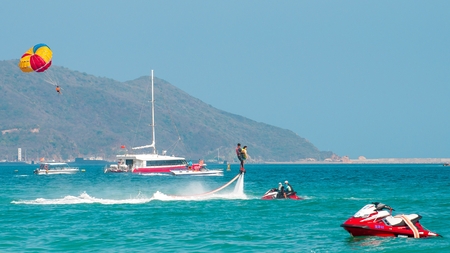 Hainan, Sanya, China - May 14, 2019: Flyboarding. Flying over the water on the board with a powerful jet of water. Attraction on the beach. Extreme sport and recreationのeditorial素材