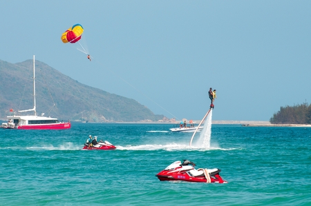 Hainan, Sanya, China - May 14, 2019: Flyboarding. Flying over the water on the board with a powerful jet of water. Attraction on the beach. Extreme sport and recreationのeditorial素材