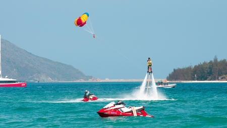Hainan, Sanya, China - May 14, 2019: Flyboarding. Flying over the water on the board with a powerful jet of water. Attraction on the beach. Extreme sport and recreationのeditorial素材