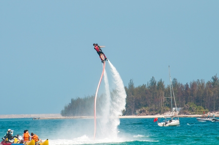 Hainan, Sanya, China - May 14, 2019: Flyboarding. Flying over the water on the board with a powerful jet of water. Attraction on the beach. Extreme sport and recreationのeditorial素材