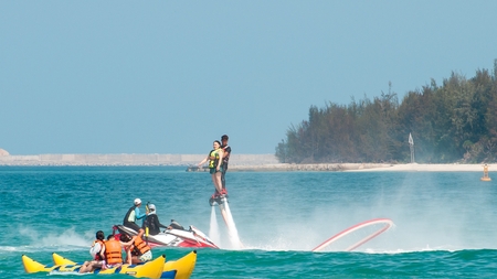 Hainan, Sanya, China - May 14, 2019: Flyboarding. Flying over the water on the board with a powerful jet of water. Attraction on the beach. Extreme sport and recreationのeditorial素材