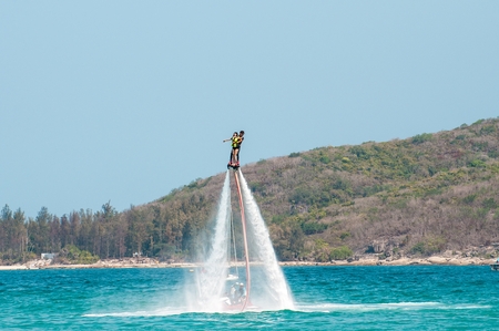 Hainan, Sanya, China - May 14, 2019: Flyboarding. Flying over the water on the board with a powerful jet of water. Attraction on the beach. Extreme sport and recreationのeditorial素材