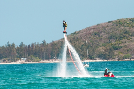 Hainan, Sanya, China - May 14, 2019: Flyboarding. Flying over the water on the board with a powerful jet of water. Attraction on the beach. Extreme sport and recreationのeditorial素材
