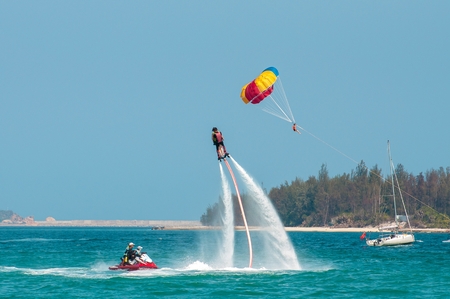 Hainan, Sanya, China - May 14, 2019: Flyboarding. Flying over the water on the board with a powerful jet of water. Attraction on the beach. Extreme sport and recreationのeditorial素材