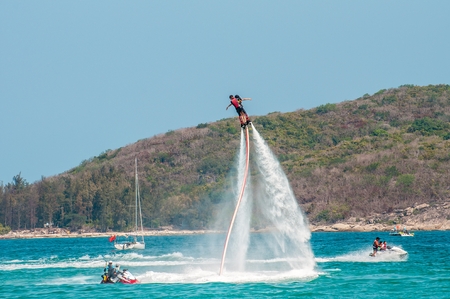 Hainan, Sanya, China - May 14, 2019: Flyboarding. Flying over the water on the board with a powerful jet of water. Attraction on the beach. Extreme sport and recreationのeditorial素材