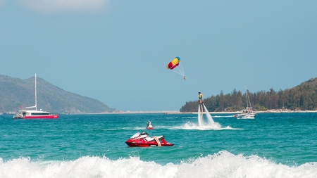 Hainan, Sanya, China - May 14, 2019: Flyboarding. Flying over the water on the board with a powerful jet of water. Attraction on the beach. Extreme sport and recreationのeditorial素材