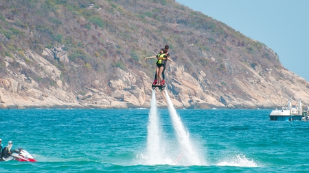 Hainan, Sanya, China - May 14, 2019: Flyboarding. Flying over the water on the board with a powerful jet of water. Attraction on the beach. Extreme sport and recreationのeditorial素材