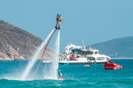 Hainan, Sanya, China - May 14, 2019: Flyboarding. Flying over the water on the board with a powerful jet of water. Attraction on the beach. Extreme sport and recreationのeditorial素材