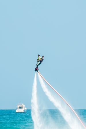 Hainan, Sanya, China - May 14, 2019: Flyboarding. Flying over the water on the board with a powerful jet of water. Attraction on the beach. Extreme sport and recreationのeditorial素材