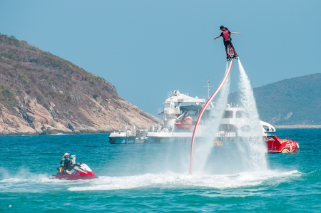 Hainan, Sanya, China - May 14, 2019: Flyboarding. Flying over the water on the board with a powerful jet of water. Attraction on the beach. Extreme sport and recreationのeditorial素材