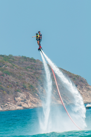 Hainan, Sanya, China - May 14, 2019: Flyboarding. Flying over the water on the board with a powerful jet of water. Attraction on the beach. Extreme sport and recreationのeditorial素材