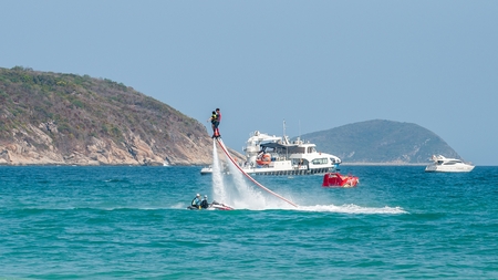Hainan, Sanya, China - May 14, 2019: Flyboarding. Flying over the water on the board with a powerful jet of water. Attraction on the beach. Extreme sport and recreationのeditorial素材
