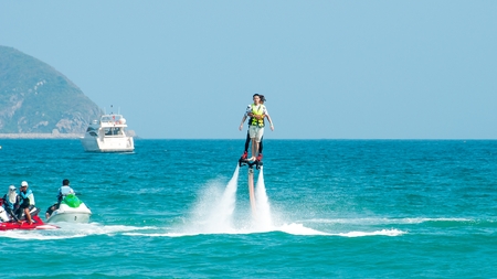 Hainan, Sanya, China - May 14, 2019: Flyboarding. Flying over the water on the board with a powerful jet of water. Attraction on the beach. Extreme sport and recreationのeditorial素材