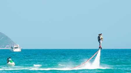 Hainan, Sanya, China - May 14, 2019: Flyboarding. Flying over the water on the board with a powerful jet of water. Attraction on the beach. Extreme sport and recreationのeditorial素材
