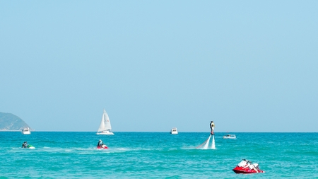 Hainan, Sanya, China - May 14, 2019: Flyboarding. Flying over the water on the board with a powerful jet of water. Attraction on the beach. Extreme sport and recreationのeditorial素材