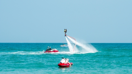 Hainan, Sanya, China - May 14, 2019: Flyboarding. Flying over the water on the board with a powerful jet of water. Attraction on the beach. Extreme sport and recreationのeditorial素材