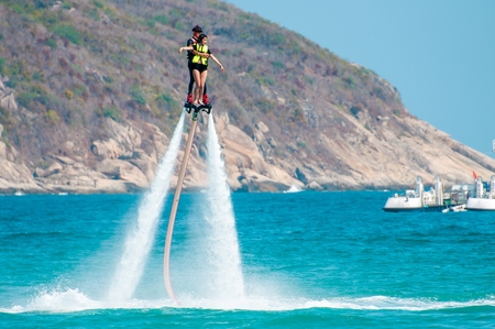 Hainan, Sanya, China - May 14, 2019: Flyboarding. Flying over the water on the board with a powerful jet of water. Attraction on the beach. Extreme sport and recreationのeditorial素材