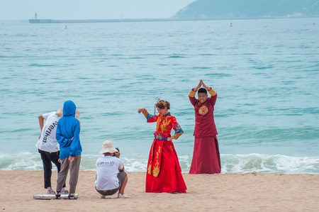 Yalong Bay beach. Backstage wedding photo session of Chinese couples. Newlyweds posing for a wedding photo shoot. Backstage photo session love storyのeditorial素材