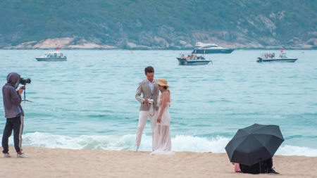 Yalong Bay beach. Backstage wedding photo session of Chinese couples. Newlyweds posing for a wedding photo shoot. Backstage photo session love storyのeditorial素材