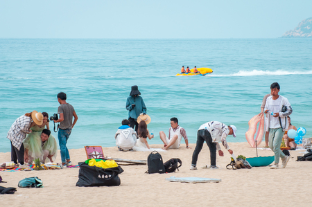 Hainan Island, Sanya city, China - May 14, 2019: Yalong Bay beach. Backstage wedding photo session of Chinese couples. Newlyweds posing for a wedding photo shoot. Backstage photo session love storyのeditorial素材