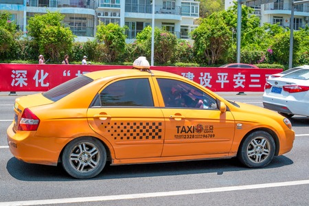 Hainan Island, Sanya, China - May 18, 2019: Taxi. Chinese yellow taxi on the street of Sanyaのeditorial素材