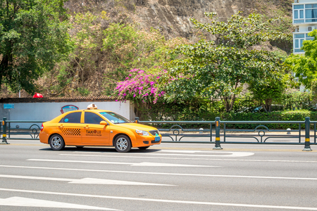 Hainan Island, Sanya, China - May 18, 2019: Taxi. Chinese yellow taxi on the street of Sanyaのeditorial素材